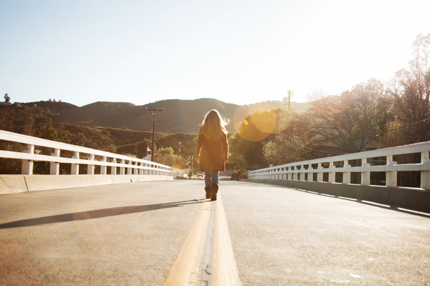 A woman walking away down the road